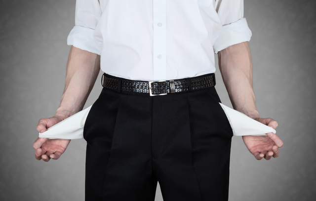 Businessman in white shirt shows empty pockets of his trousers